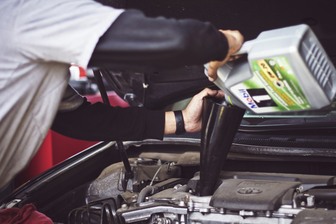 Technician working beneath a raised vehicle